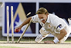 Australia's Andy Bichel dives at the stumps as he runs out West Indies batsman Courtney Walsh during the second day of the fourth Test at the Melbourne Cricket Ground on Wednesday.
