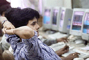 A broker relaxes while he watches his trading screen on a slow day in a Bombay brokerage on Friday
