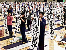 Some 500 participants stand up to show off their papers with calligraphy written on them during a stage of an annual New Year's calligraphy contest in Tokyo.