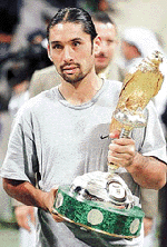 Chiles Marcelo Rios with the trophy after he won his match against Czech Republics Bohdan Ulihrach in the Qatar Open tennis tournament in Doha on Sunday.