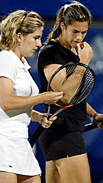 Amelie Mauresmo (right) and compatriot Emilie Loit of France discuss tactics during the during the first round of the Sydney International tennis tournament on Monday.