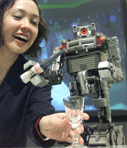 Dream Force 01, a 350mm-high robot developed by toymaker Takara, pours a glass of wine for Takara employee Terumi Endo in Tokyo on Tuesday.