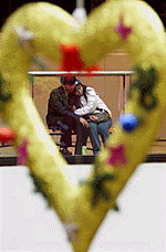 A Chinese couple enjoys a quiet moment as they are framed by a heart-shaped decoration hanging down from the ceiling of a shopping centre in Beijing on Saturday.