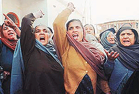 Kashmiri Sikh women raise their arms and shout "we want migration" at Mehjoor Nagar in Srinagar, the summer capital of Jammu and Kashmir in India on Monday.