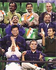 Indian fans wave flags and cheer Leander Paes playing against Japan's Yaoki Ishii during the Davis Cup tennis between India and Japan
