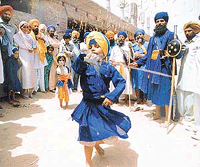 People enjoying a performance of gatka (a martial art of Nihangs) at Talwandi Sabo on Saturday, the concluding day of the Baisakhi mela. 