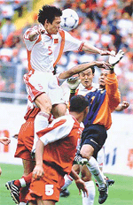 Chinas Fan Zhiyi (top) outjumps Indonesias goalkeeper Kartiko Hendro (R) during a World Cup soccer Asian zone group nine qualifying match in Kunming, Yunnan province, on Sunday.