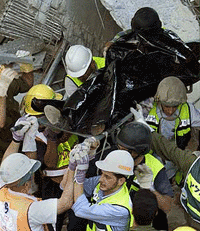 Israeli rescue workers remove a body from the rubble of a multistoreyed banquet hall in Jerusalem, that collapsed during a wedding party on Friday.
