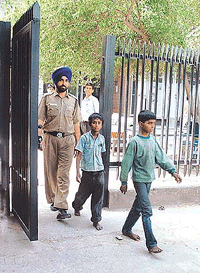 A sad walk into captivity: Two boys, 10-year-old Dinesh and Arshi, being escorted to a juvenile home from the District Court Complex in Chandigarh. A magistrate has ordered that they should be kept in the home till May 28.