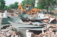 A JCB in the process of demolishing illegal jhuggis in Sector 31 of Chandigarh on Sunday.