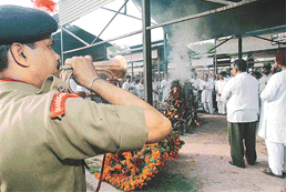 A policeman sounds the bugle even as the funeral pyer of former Union Minister, Jagannath Kaushal is lit at the Cremation Ground, Sector 25 in Chandigarh on Thursday. 