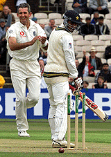 Abdur Razzaaq (R) looks over his shoulder at his shattered stumps while Andrew Caddick celebrates during the second Test at Old Trafford.