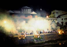 Smoke rises into the night sky during the cremation.