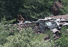 An Indian soldier waves to visitors at a military bunker on the Pakistan side on the Line of Control (LOC) in Chakothi May 28, 2001.
