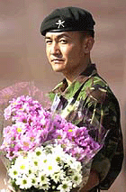 A Gurkha soldier holds  flowers during a memorial parade in Folkestone, England, on Monday, for slain members of the Nepalese Royal family.