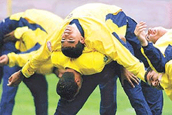 Brazilian football player Menezes Hubner Ramon (top) stretches with a Brazil team-mate on Tuesday during a training session at Seoul Olympic Stadium.