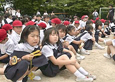 Schoolchildren weep on the grounds of Ikeda elementary school in Osaka on Friday after fleeing from their classrooms.