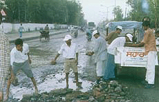 Sahara workers repair Guru Kanshi Marg, the main road in Bathinda.