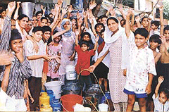 Women and children wait for water at a common tap in a locality in Ludhiana. 
