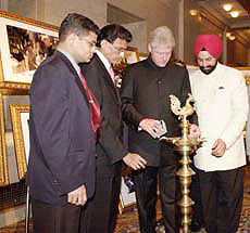 Former US President Bill Clinton lighting a lamp to inaugurate a photo exhibition of Indian American photojournalist Mohammad Jaffer (extreme left) in New York on Tuesday. 