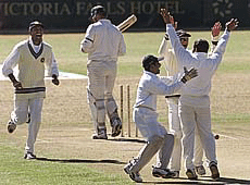 Indian players Venketsai Laxman (L), wicket keeper Samir Dighe and Hemang Badani celebrate the dismissal of Zimbabwe batsman.