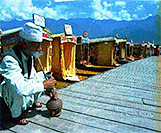 An elderly shikara owner taking a strong puff from his traditional Kashmiri "HUKA" in famous Dal lake.