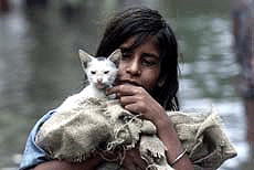 Pinki Das carries her cat to a safer place after the pavement she sleeps in came under water due to heavy rain in Kolkata on Monday.