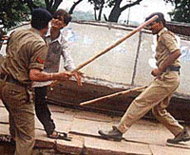 Police personal trying to disperse the agitated mob outside a cine hall where film "Gadar" was screened in Bhopal on Tuesday.