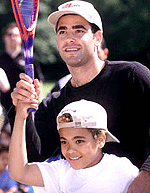 US tennis star Pete Sampras coaches Igo Dossantos at Park House School in Wimbledon, London, on Tuesday. Sampras is in London ahead of the Wimbledon, due to start on June 25. 