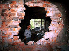 A teenaged boy looking at the destruction of his house which was damaged during a gunfight between militants and army at Goplapora in Badgam district of central Kashmir on Wednesday night. 