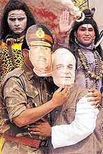 Activists from the Mahadev Sevada religious group hug each other while wearing masks of Indian Prime Minister Atal Behari Vajpayee (R) and Pakistani President Pervez Musharraf during a demonstration in New Delhi on Friday