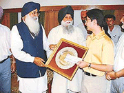 Abhinav Bindra receiving a cheque of Rs 10 lakh and a plaque from Punjab Chief Minister Parkash Singh Badal in Chandigarh on Saturday as Capt Kanwaljeet Singh, Punjab Finance Minister looks on.