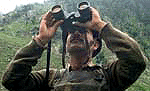 A BSF jawan looks through his binoculars towards the forest and mountain peaks at Chandanwari, 111 km southeast of Srinagar, on Sunday. 