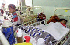 Children wait for medical attention in a hospital on Sunday.