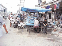 Encroachers have occupied a large part of the road leaving little room for pedestrians to walk. 