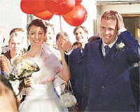 German soccer star Oliver Bierhoff, currently playing for Italian team AC Milan, and his wife Klara walk though a cheering crowd after their wedding in the church of Oberflossing, southern Germany on Saturday. 