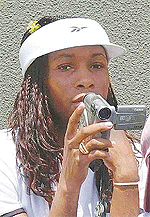 Defending champion Venus Williams uses a video camera to tape sister Serena, during her women's singles first round match against Rita Kuti Kis of Hungary, on the opening day of Wimbledon championships on Monday. 