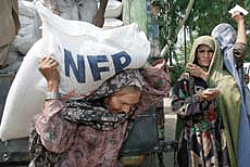 An elderly Afghan refugee shoulders a bag of flour distributed by the UN World Food Programme in the Jalozai refugee camp, 110 km west of the Pakistani capital, Islamabad, on Tuesday.
