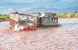 Two trucks lie submerged in the flooded Ghaggar near Mubarikpur village on Tuesday.