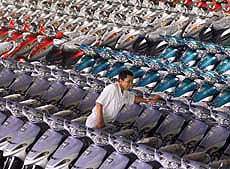 An Indonesian worker squeezes between new motorcycles at the Jetmatic Kymco motorcycle factory in Bekasi, near Jakarta, on Thursday.