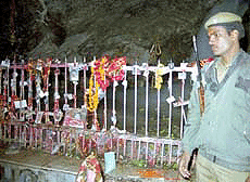 A para-military jawan stands guard in front of the ice lingam of Lord Shiva at the holy cave shrine of Amarnathat a height of 3952 meters above sea level in south Kashmir.