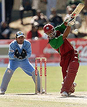 West Indies batsman Marlon Samuels drives a delivery watched by Indian wicket keeper Samir Dighe on Saturday. 
