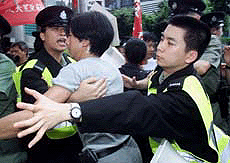 A protester confronts policemen as he demonstrates with 10 pro-democracy activists near a flag raising ceremony to mark the fourth anniversary of Hong Kongs handover to Chinese rule on Sunday.
