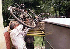 A man lifting his bicycle over the police barricade during a BJP demonstration in New Delhi on Monday.