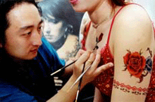 A young Chinese woman receives a henna tattoo at a body art salon in Tangshan, Hebei province, on Monday.