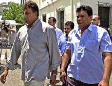 Three Indian men are led handcuffed out of the main port police building in Piraeus on Wednesday.
