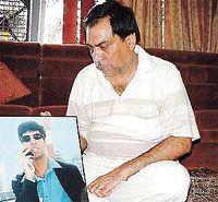 A distraught Mr Sunil Vermani with the portrait of his son, Manav, who was shot in the USA by robbers.
