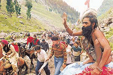 A sadhu blesses pilgrims at Pishutop, 116 km southeast of Srinagar, as they make their way to the holy cave of Amarnath on Thursday. 