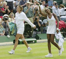 Defending Champion Venus Williams waves to the crowd, as she walks off court with the defeated Lindsay Davenport, after their women's singles semifinal on the Centre Court at Wimbledon on  Thursday.