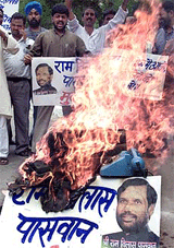 Activists burn telephone equipment along with a photo of Communication Minister Ram Vilas Paswan during a demonstration near Parliament in New Delhi on Saturday.